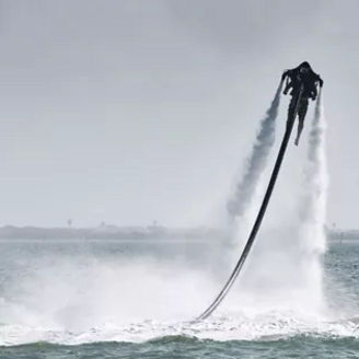 Person mit Jetpack, die aus dem Meer in den Himmel startet