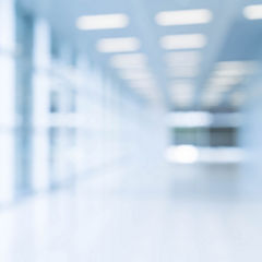 Blurred abstract background interior view looking out toward to empty office lobby and entrance doors and glass curtain wall with frame