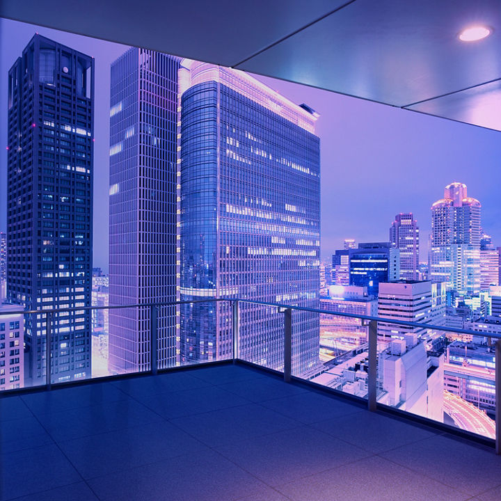 Looking out at the futuristic skyline of Osaka Japan at dusk from a residential balcony high above the city