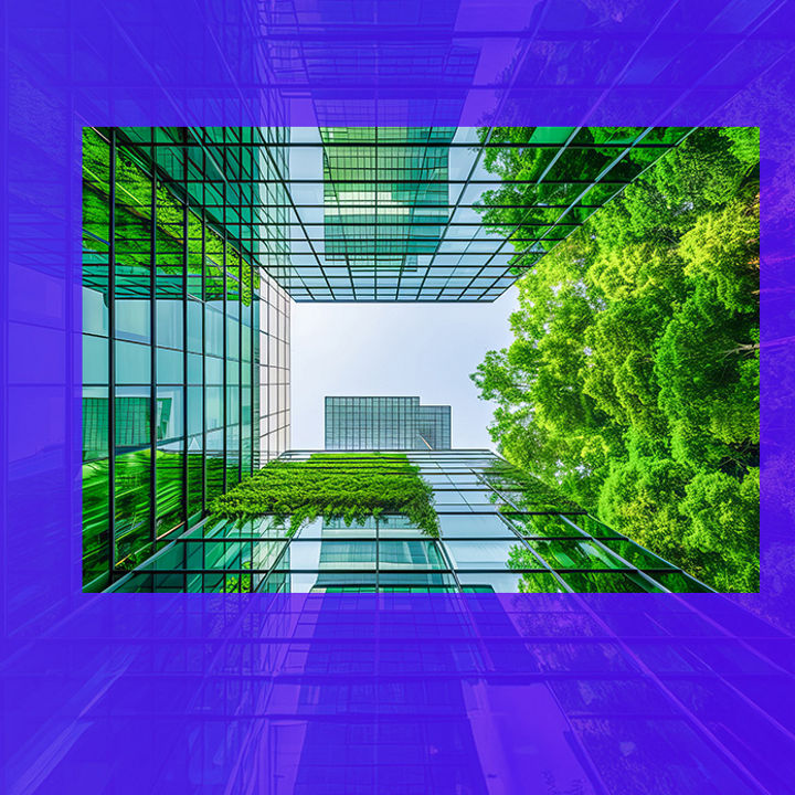 Looking up at a glass building with trees banner
