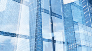 Four statues in front of buildings with blue sky above