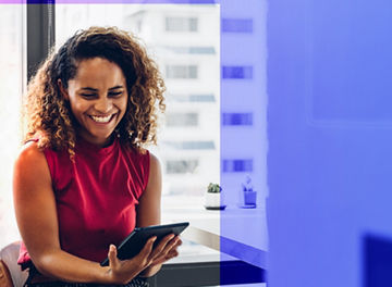 Person smiling whilst holding a tablet