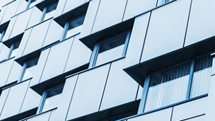 Abstract fragment of modern architecture, walls made steel with shiny windows. Blue tonal filter photo effect