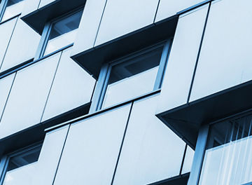 Abstract fragment of modern architecture, walls made steel with shiny windows. Blue tonal filter photo effect