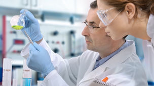 試験管を確認する二人の白衣の研究員