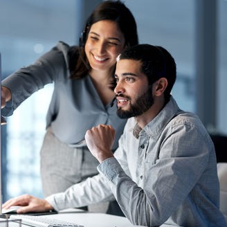 Shot of a young woman helping her colleague in a call centre late at night