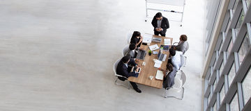 Top view of group of multiethnic busy people working in an office, Aerial view with businessman and businesswoman sitting around a conference table with blank copy space, Business meeting concept