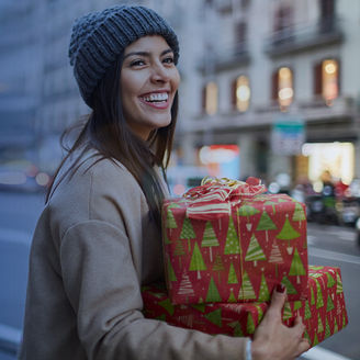 lady in winder clothing holding christmas gifts