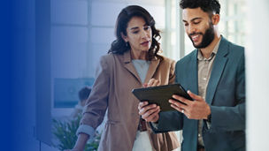 woman and man discuss while holding a tablet