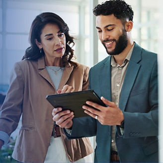 woman and man discuss while holding a tablet
