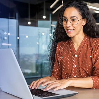 woman with dark orange shirt working on her laptop
