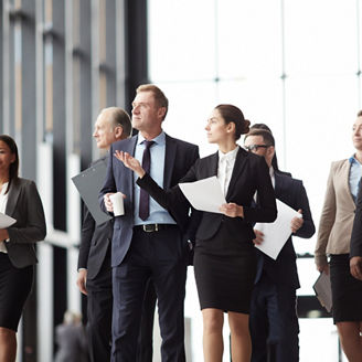 Young elegant woman with paper pointing right while showing colleagues new conference hall for running political events