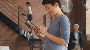 Person working on a tablet and smiling