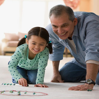 grandfather-granddaughter-playing-marbles-on