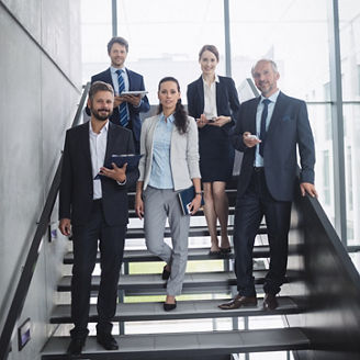 Portrait of confident businesspeople standing on staircase in office