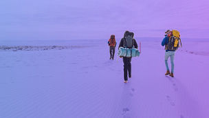 groep mensen aan het hiken in de sneeuw met rugtassen op