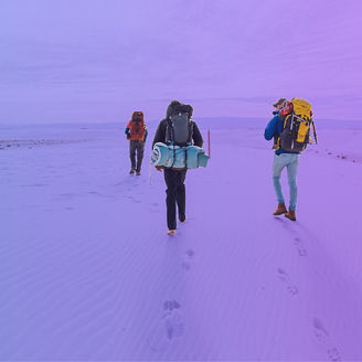 groep mensen aan het hiken in de sneeuw met rugtassen op