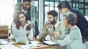 group of employees looking at laptop