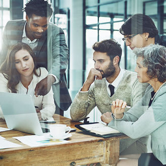 group of employees looking at laptop