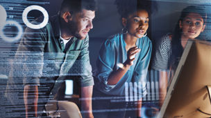 Group of programmers working together on a computer code at night banner