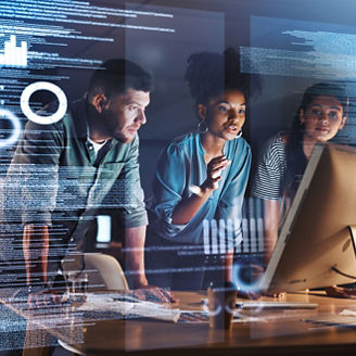 Shot of a group of programmers working together on a computer code at night