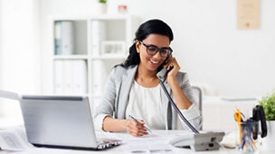 business, technology, communication and people concept - happy smiling businesswoman with papers calling on phone at office