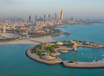 A high-angle shot of The Green Island with a skyline of the city of Kuwait in the background