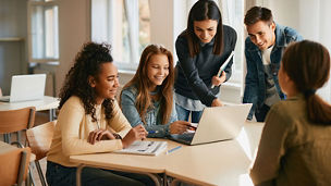 Diverse group of high school students gathered around a laptop