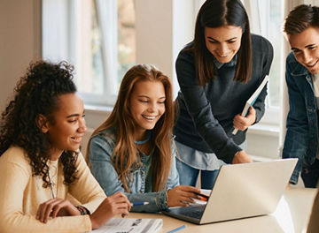 Diverse group of high school students gathered around a laptop