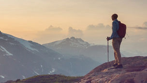 Hiker looking over mountains at sunrise