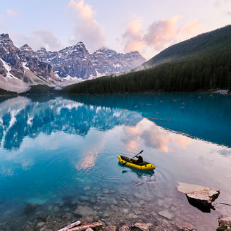 Fotografía de una persona navegando un lago en un kayay