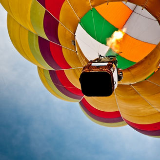Colourful hot air balloon flying in sky.