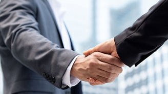 Businessmen making handshake outdoors in city office building background for merger and acquisition concept
