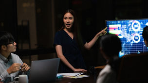 Asia businessmen and businesswomen meeting brainstorming ideas conducting business presentation project colleagues working together plan success strategy enjoy teamwork in small modern night office.