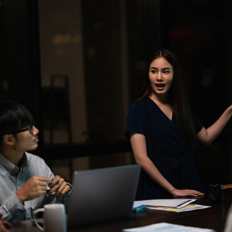 Asia businessmen and businesswomen meeting brainstorming ideas conducting business presentation project colleagues working together plan success strategy enjoy teamwork in small modern night office.