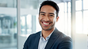 Asian business man, arms crossed and face in office, smile and pride for leadership, management and professional. Financial advisor, businessman and happy in portrait, suit and ambition in workplace.