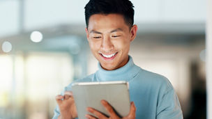 Asian man with tablet, smile and scroll, thinking and reading email, review or article at startup. Internet, research and happy businessman with digital app for with networking, social media or web