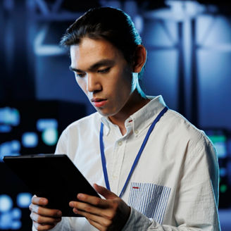 Tech support worker between server room equipment providing processing resources for businesses worldwide. Skillful developer fixes data center supercomputers used for managing massive databases