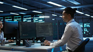 Engineer overseeing data center, making improvements and updates to ensure system can handle networking tasks, handheld camera shot. Indian man in server room tracking network traffic, camera B