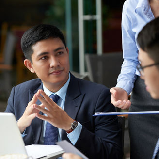 Handsome young businessman having meeting with partners in cafe