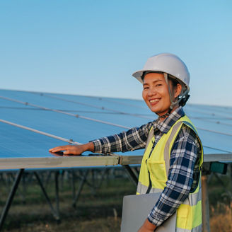 Young asian female inspector engineer touching to checking operation photovoltaic solar panel in outdoor station, holding laptop computer and looking camera with smile, copy space