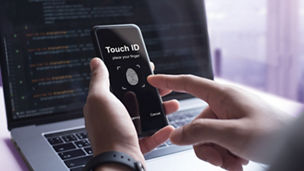 Man holding phone and attempting to unlock it with his finger by using his finger ID