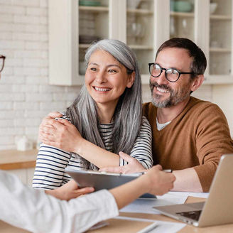 Smiling couple in meeting with broker representing Unlocking AI in Insurance report