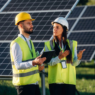 Two solar engineers standing together at a photovoltaic field representing Energy taxes in Budget 2027