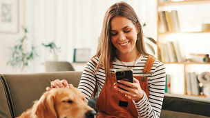 Phone, relax and woman on sofa with dog for bonding representing Budget 2027 headlines