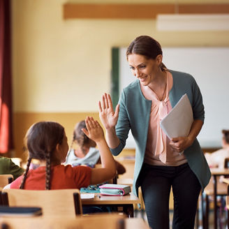 Happy elementary school teacher giving high-five to her student representing income tax in Budget 2027