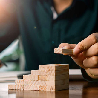 Person building blocks in office representing building to scale