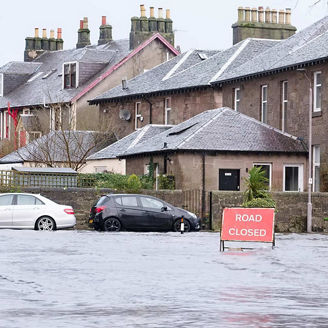 Road flood closed sign under deep water during bad extreme heavy rain storm weather in UK