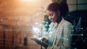 Woman looking at tablet with icons overlaid representing compliance and controls