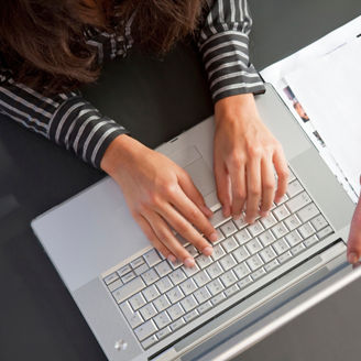 Close-up detail of businessman's hand pointing to laptop